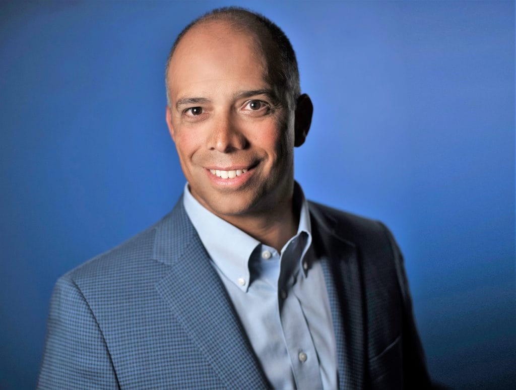 Nando Zucchi in a blue dress shirt and suit coat.