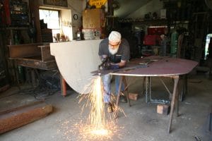 Jay (JBONE) Sawyer in shop welding piece of metal for El Faro Salute Project