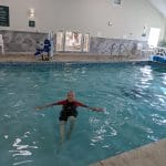 Robin G Coles in an Airtime Waterline wet suit losing her fear of swimming and sculling in a hotel pool